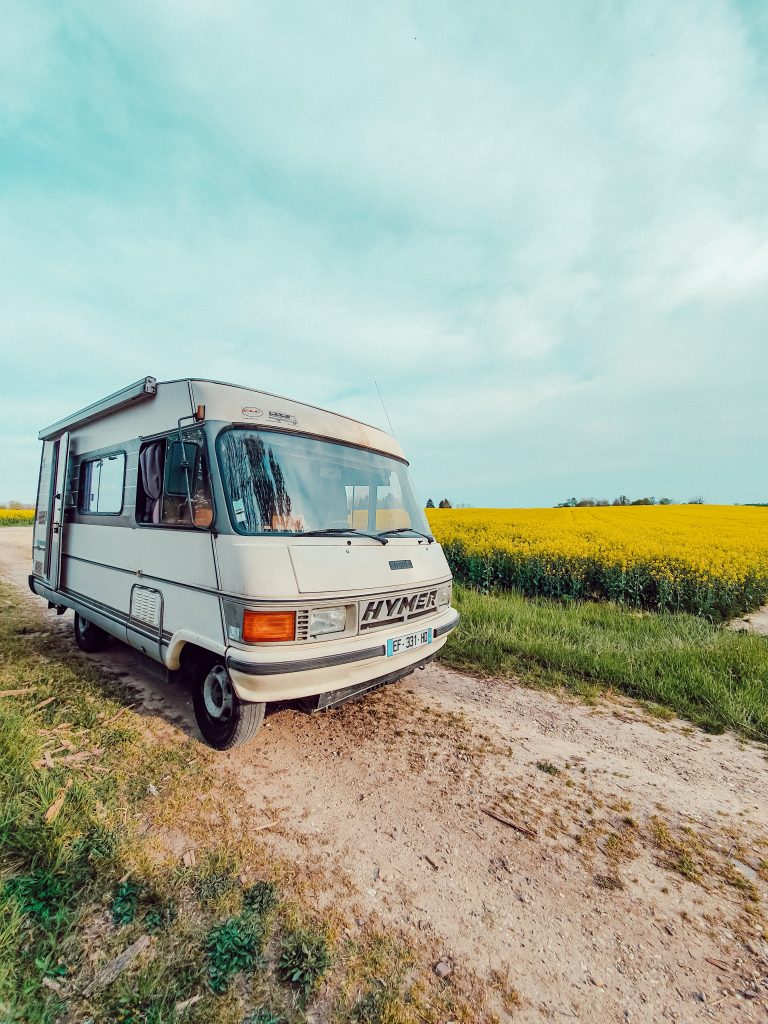 camping-car hymer dans un champ de fleurs jaunes