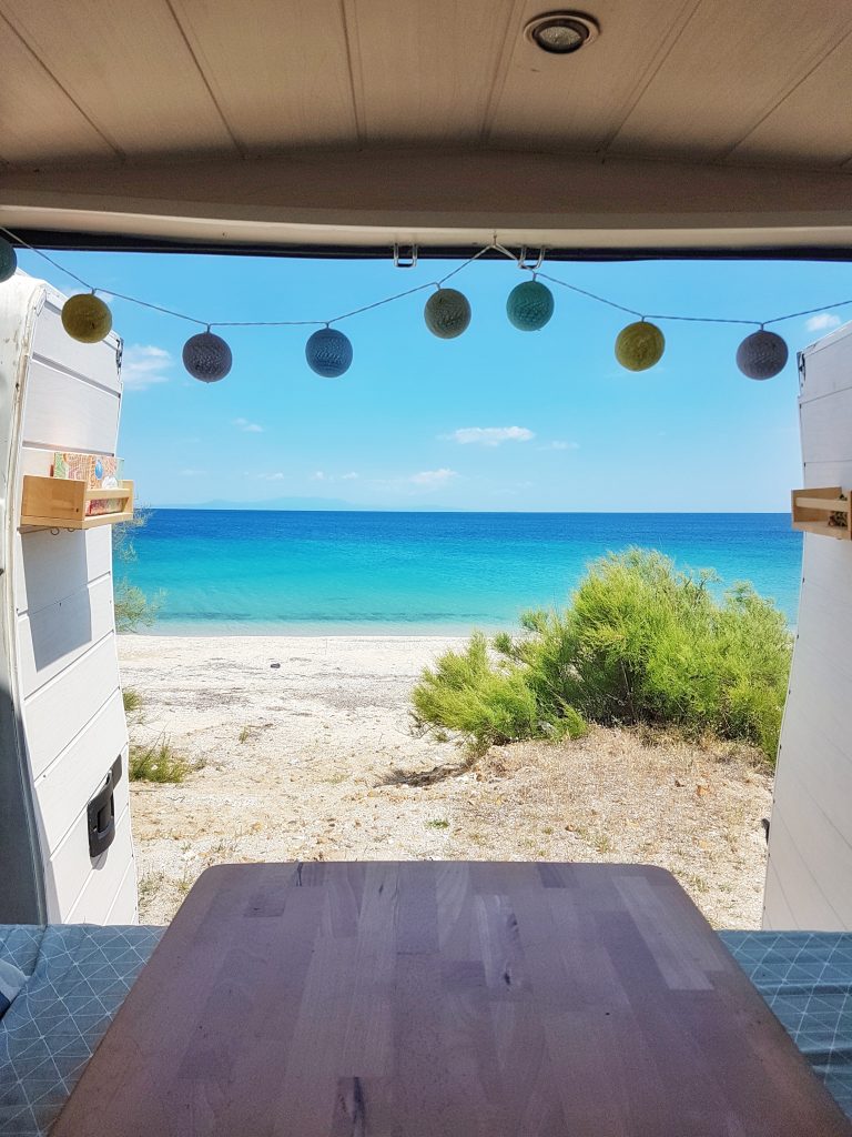 vue sur une plage en Gr&egrave;ce depuis un l'int&eacute;rieur d'un fourgon am&eacute;nag&eacute;