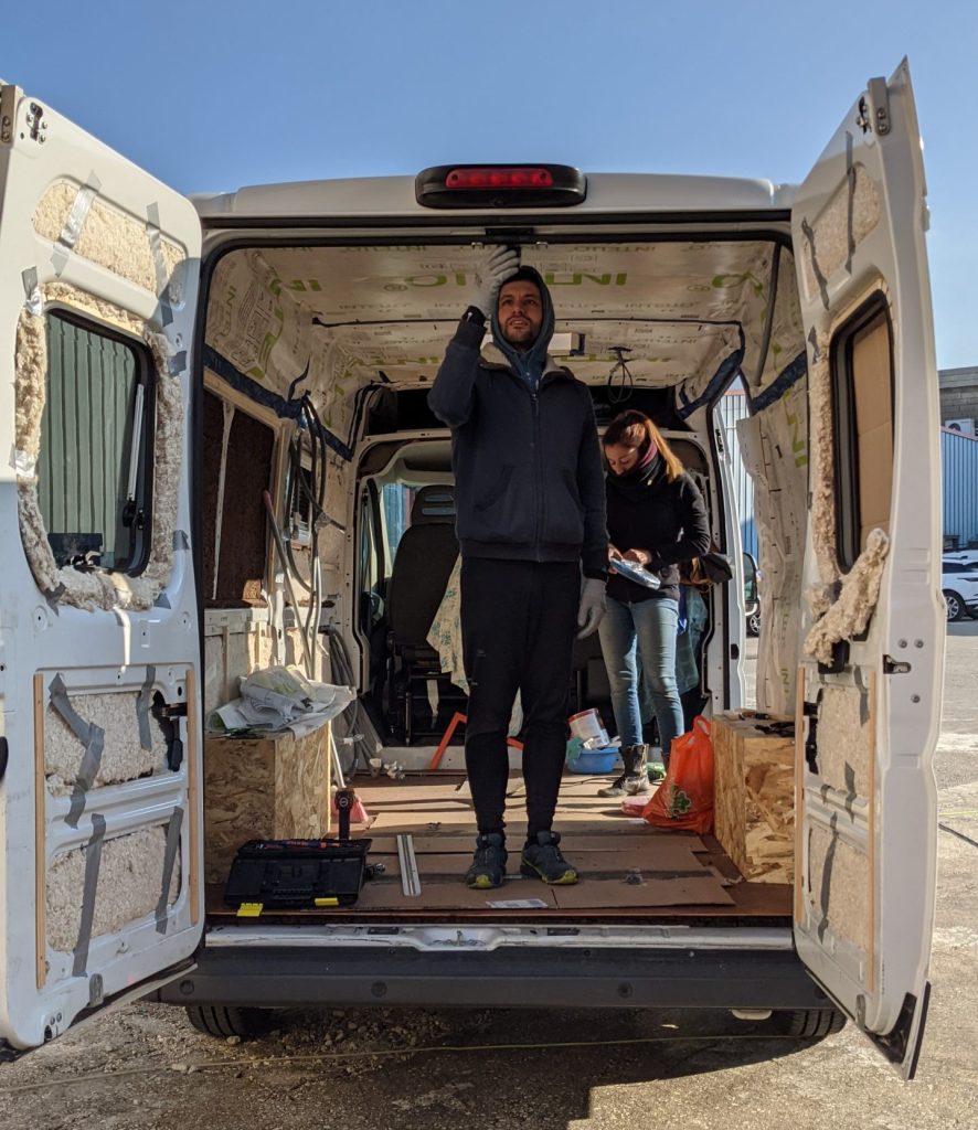 homme qui isole un fourgon aménagé