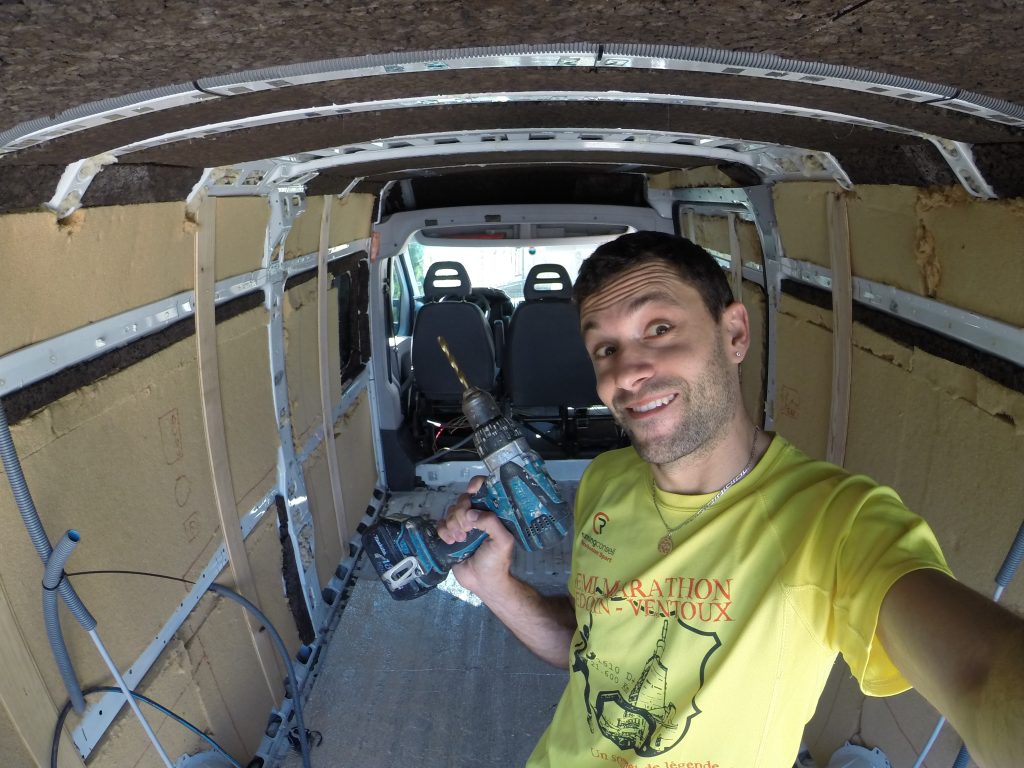 homme qui isole un fourgon avec laine de bois