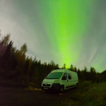 fourgon blanc en norvège avec aurore boréale