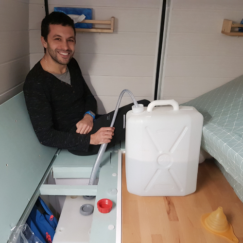 remplissage de l'eau par des jerricane dans un fourgon